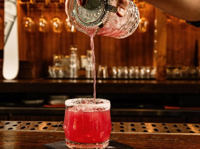 Bartender pouring cocktail at Versante Hearth and Bar
